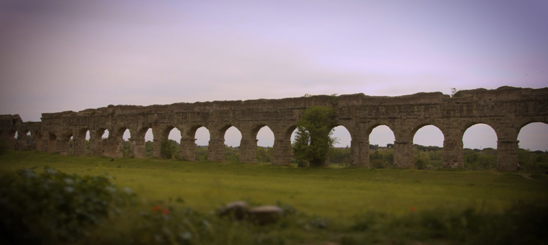 View along a section of a stone aqueduct in a field