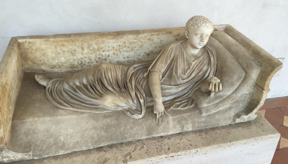Marble statue on the lid of a sarcophagus