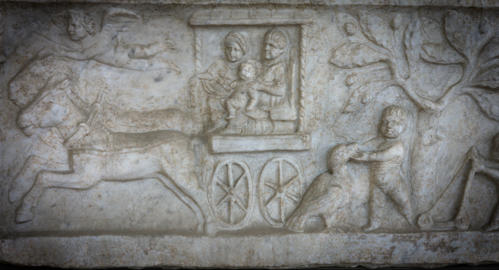 Detail of a marble relief showing figures in a horse drawn cart, and a boy playing with a goose.