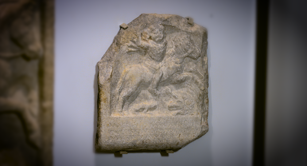 Marble slab with a carving of a figure on horseback and a Latin inscription